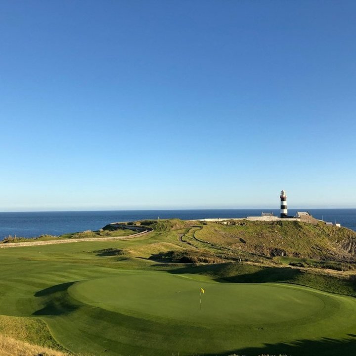 Golfbana vid havet och en fyr